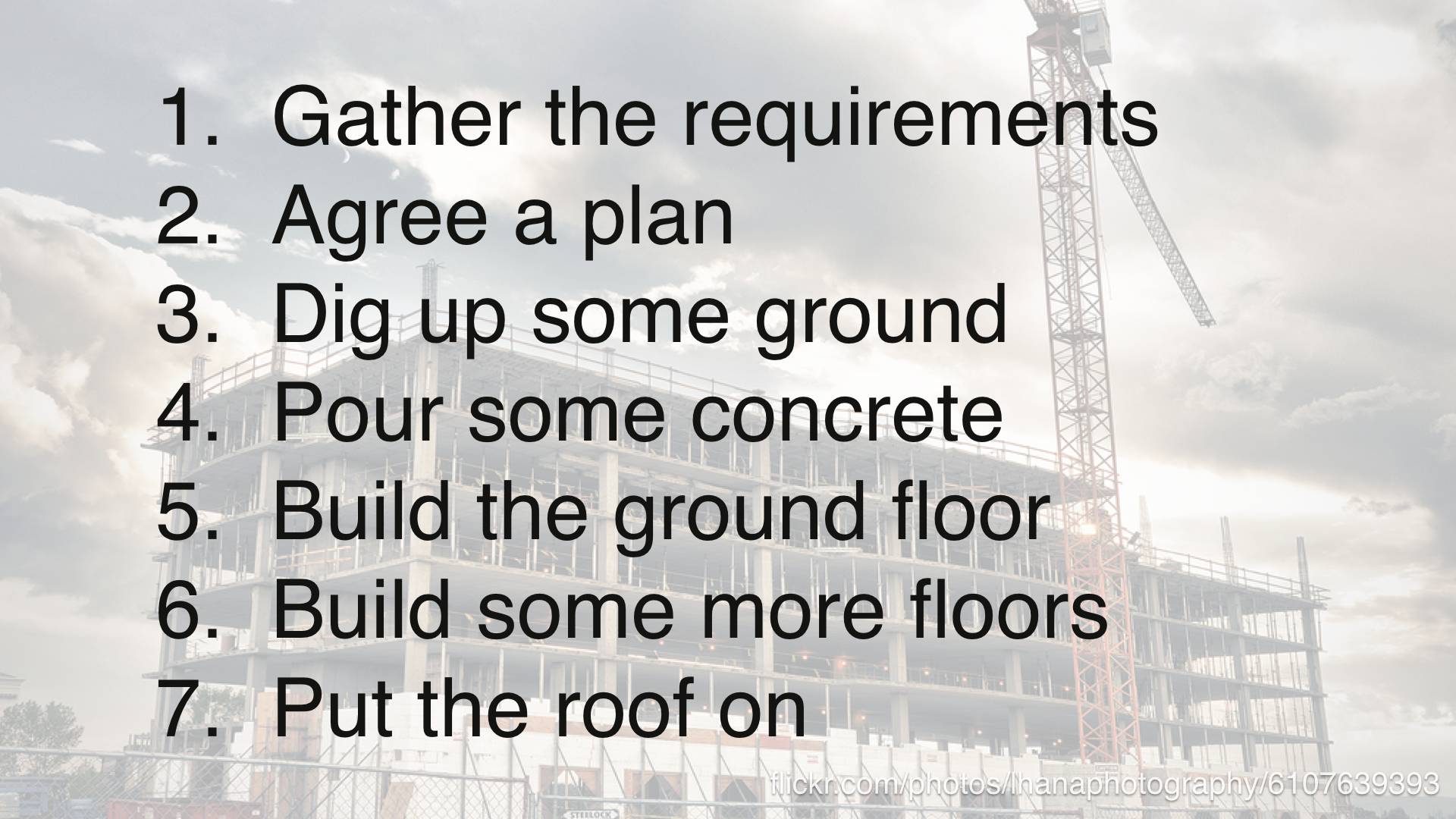 1. gather the requirements. 2. agree a plan. 3. dig up some ground. 4. pour some concrete. 5. build the ground floor. 6. build some more floors. 7. put the roof on